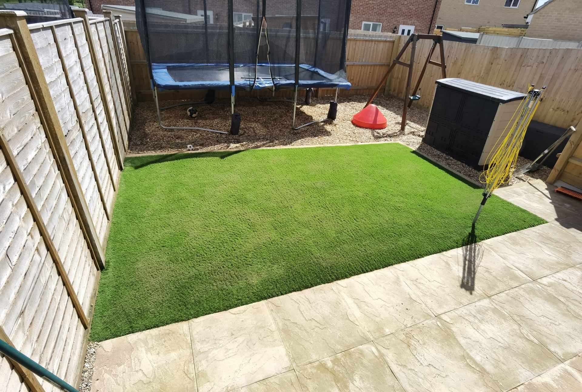 Artificial grass installation Suffolk — Bright green synthetic turf installation with patio edging and play area