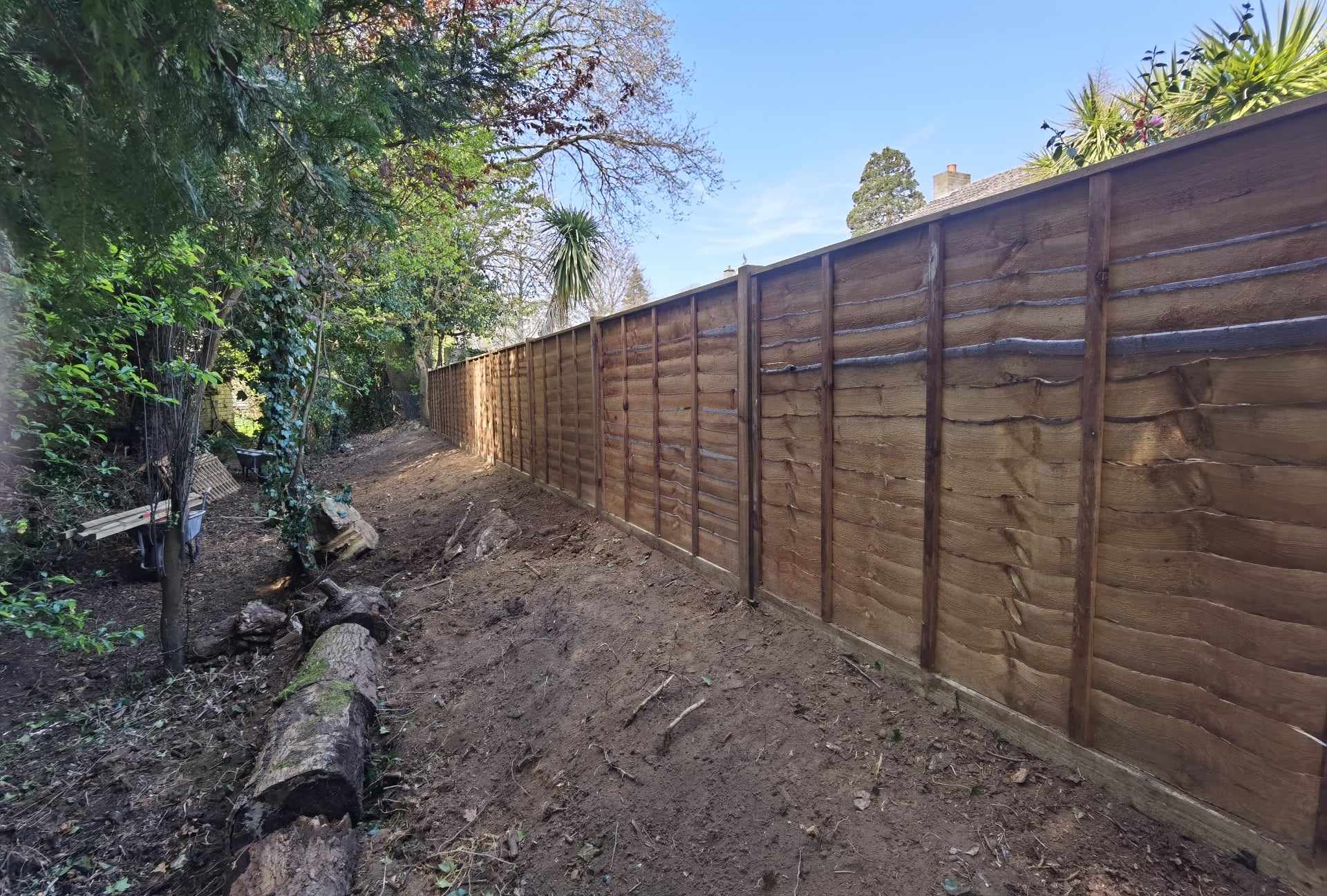 Fencing & gates Suffolk — New wooden fence installation along garden border with posts